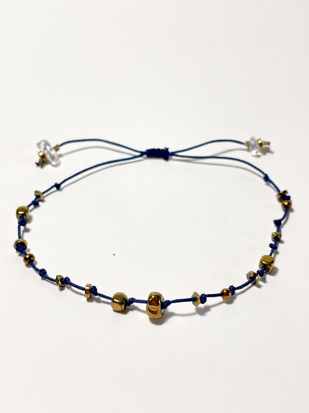 bracelet fin en hematite dorée, noeud coulissant bleu foncé