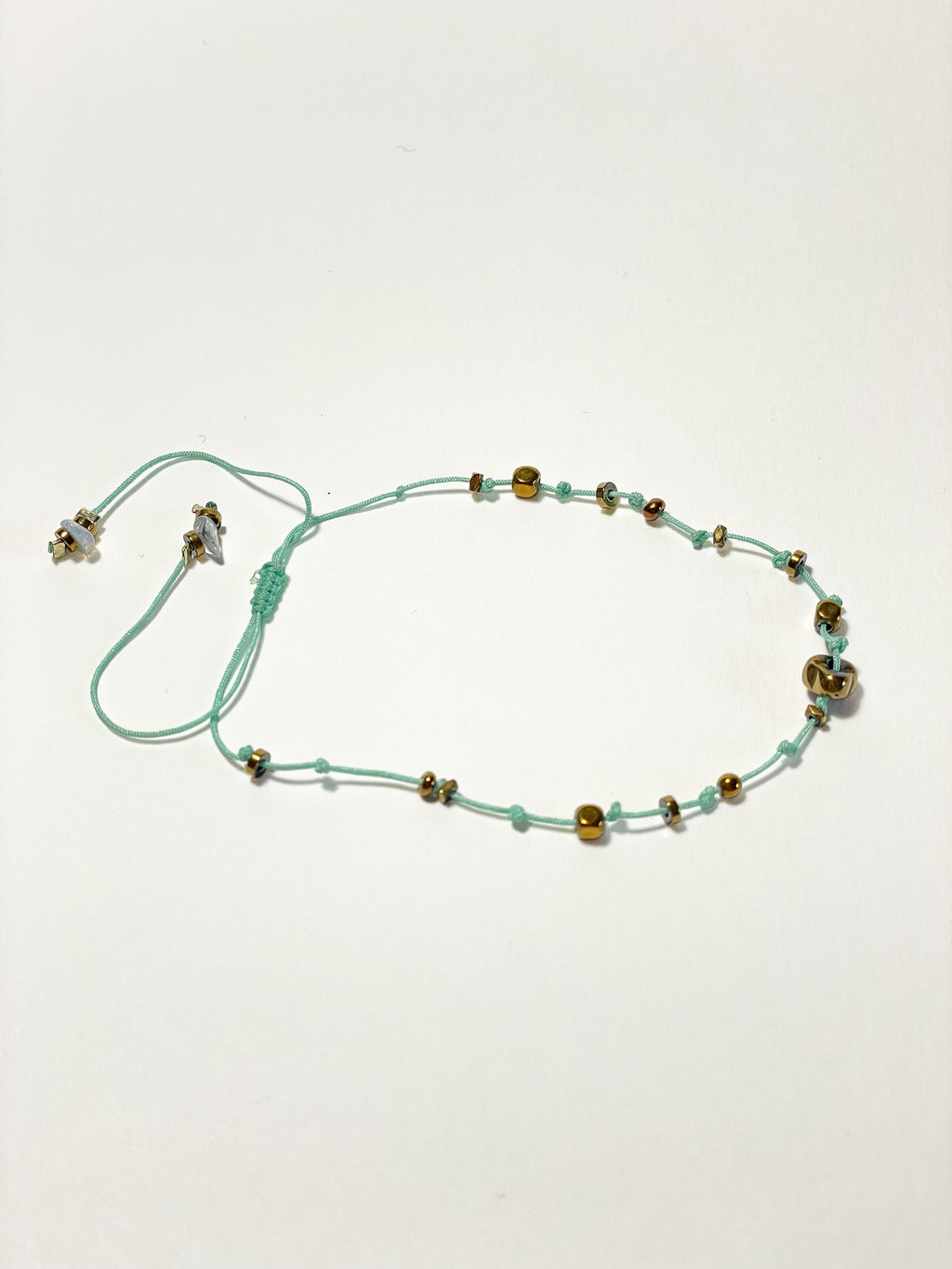bracelet fin unisexe en hematite dorée, noeud coulissant céladon