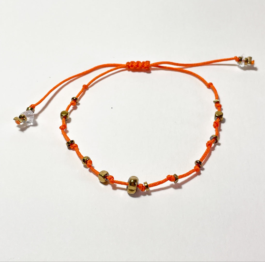 bracelet fin en hematite dorée, noeud coulissant orange